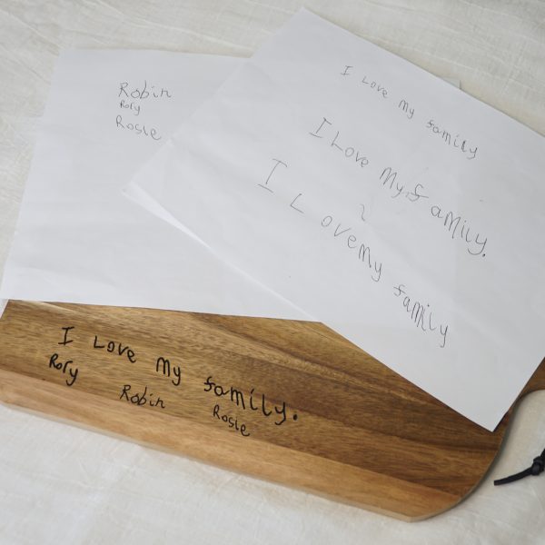 Children's handwriting on a chopping board