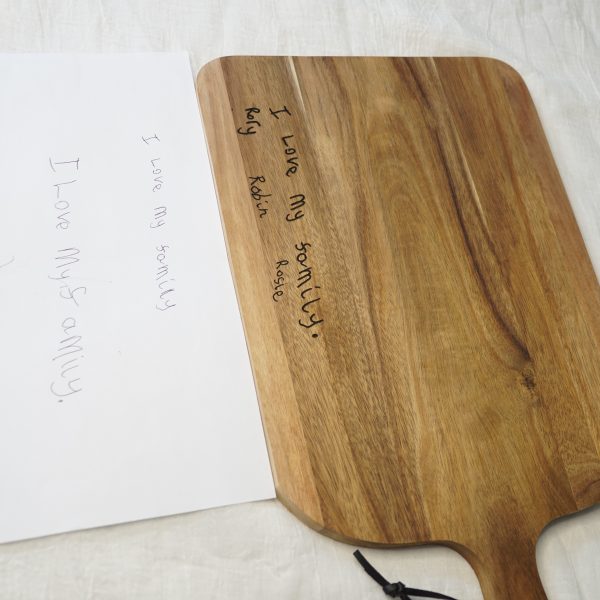 Children's handwriting on a chopping board