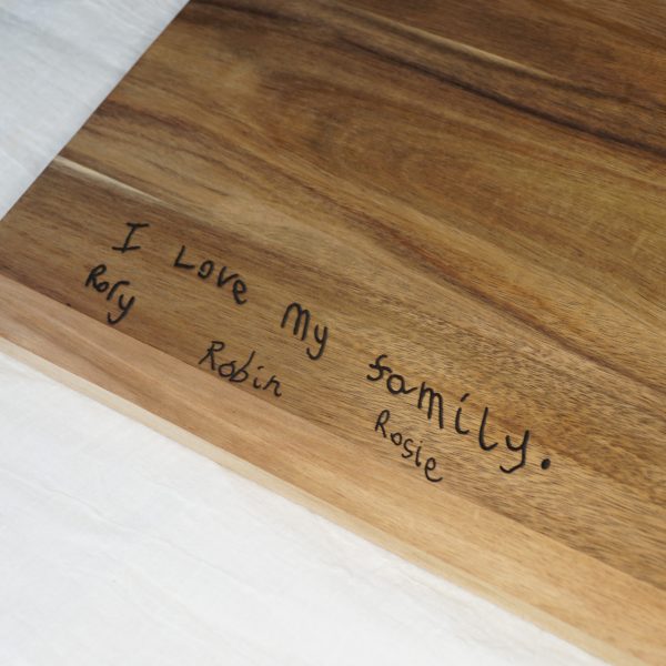 Children's handwriting on a chopping board